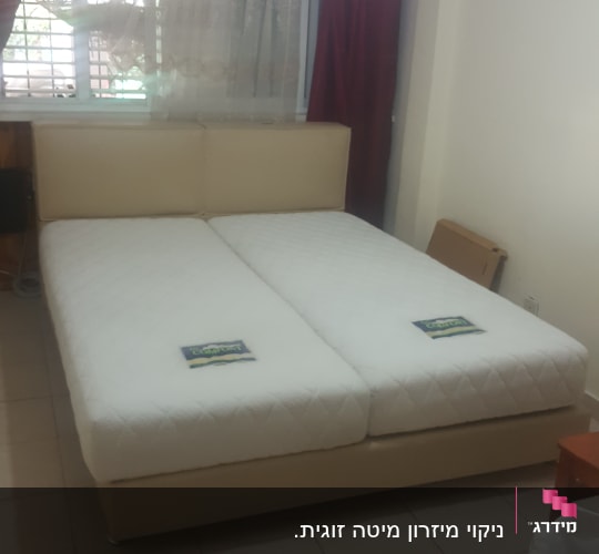 מיטה זוגית עם מזרנים לבנים בחדר שינה